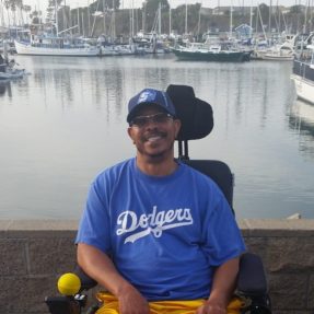 George A. Crockett, Jr. is seated in a wheelchair in front of a body of water.